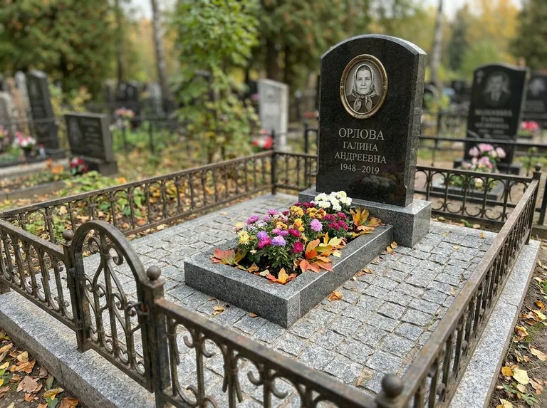 Благоустроенное захоронение с гранитной плиткой, оградой и цветником в Нижневартовске