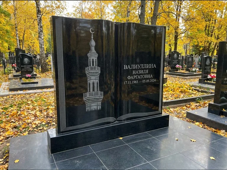 Мусульманский памятник с гравировкой мечети: стела в форме раскрытой книги на подставке — белая гравировка силуэта мечети с минаретами, цоколь тёмной плиткой, работа «Исмаилова» в Нижневартовске