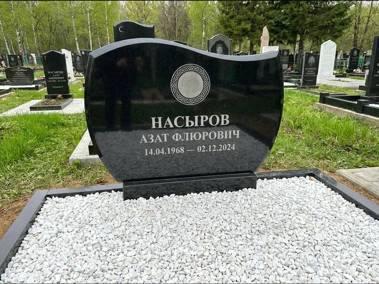 Мусульманский памятник: стела с волнообразным скошенным верхом — гравировка мечети под полумесяцем и звёздами, белая мраморная крошка с бордюром, работа «Насыров» в Нижневартовске