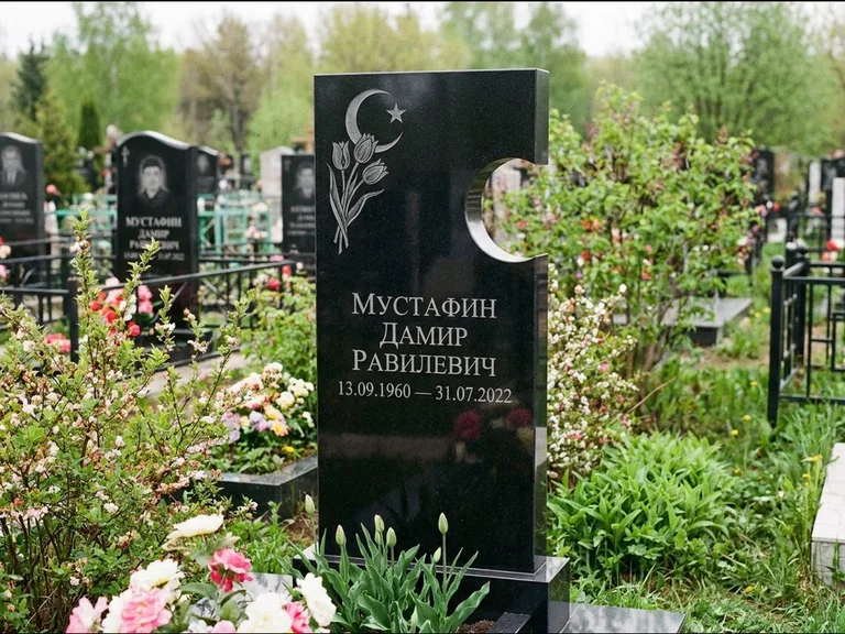 Мусульманский памятник: стела с боковым вырезом в форме полумесяца — гравировка минарета с полумесяцем, низкие кусты в цвету, работа «Мустафин» в Нижневартовске