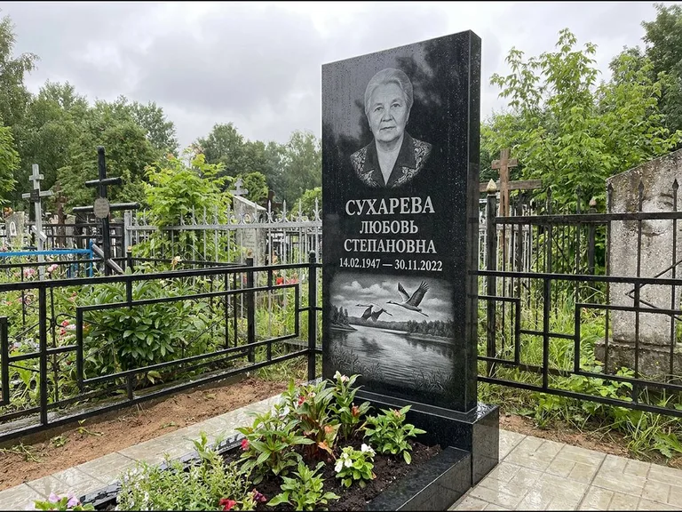 Памятник с гравировкой журавлей — гравировка пары журавлей над гладью озера в нижней части, работа «Сухарева» в Нижневартовске