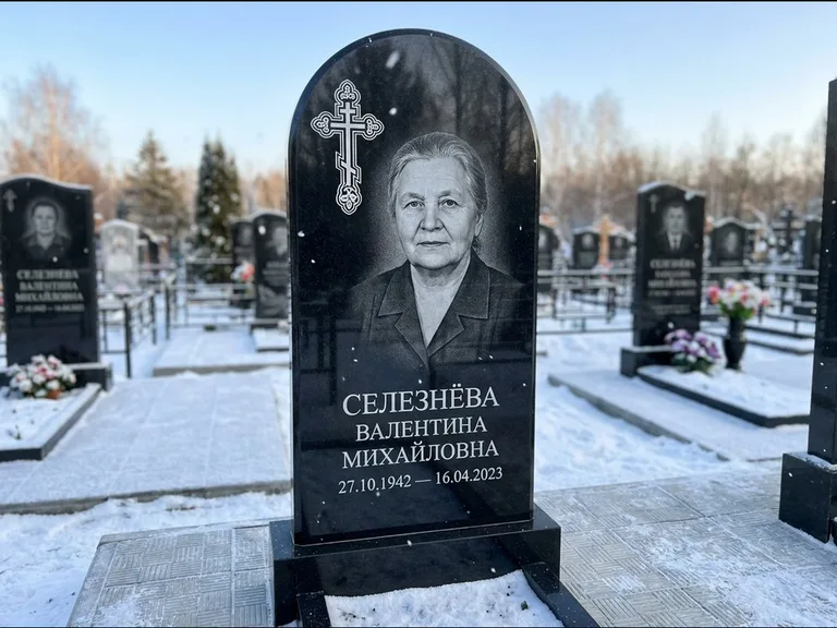 Памятник из чёрного гранита — массивная стела с крестом в лучах с крестом в лучах, работа «Одинцова» в Нижневартовске